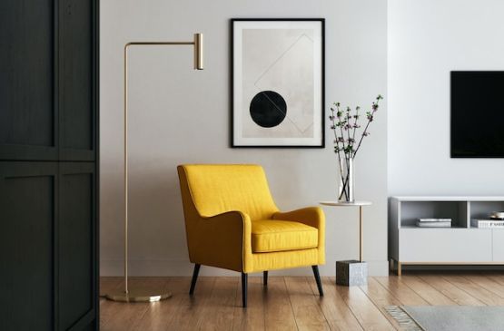 Fauteuil jaune sur parquet en bois clair avec un meuble bas blanc