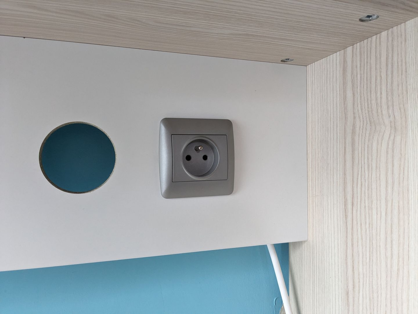 In eine Maßanfertigung integrierte Steckdose dank einer kreisförmigen Bohrung von 68 mm