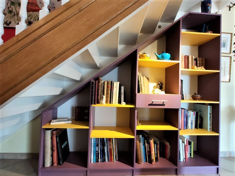 Bibliothèque sur mesure colorée sous escalier